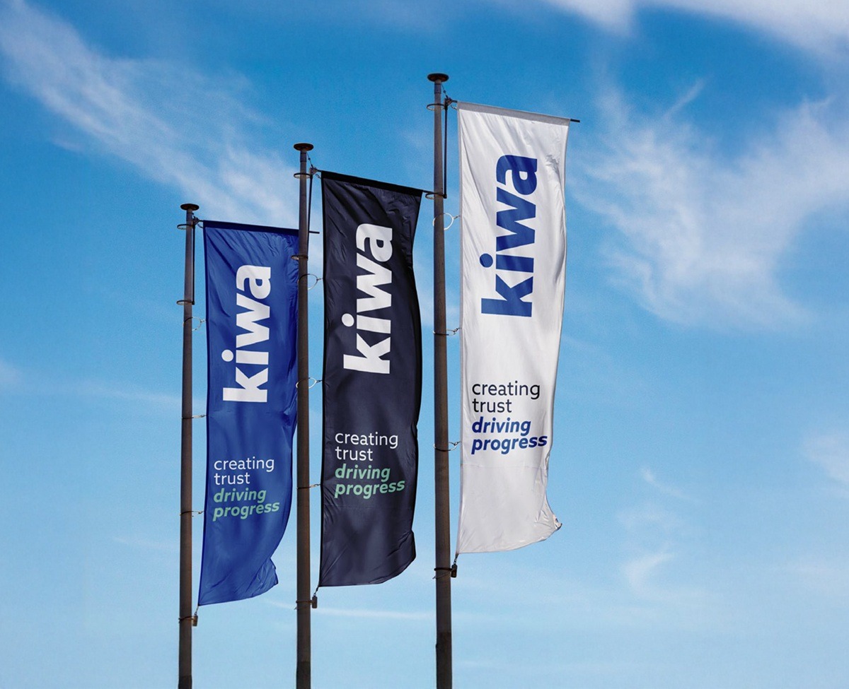 Three vertical Kiwia flags in blue, black, and white against a blue sky, each reading “creating trust driving progress.”